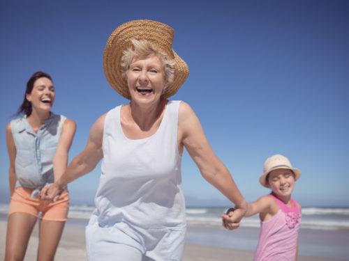 Cheerful multi-generation family at beach during sunny day